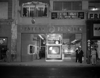 Hombres junto a la tienda "general electric"