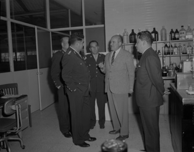 Militares y hombres conversan en laboratorio de empacadora de alimentos