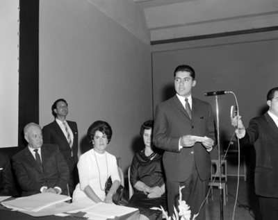 Hombres con documento junto a un microfono