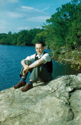 Arsen sentado sobre una roca a la orilla de un lago, retrato