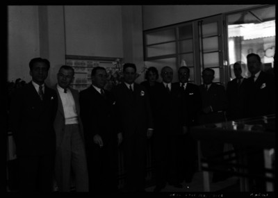 José María Tapia con hombres y mujeres durante una reunión en una sala, retrato de grupo
