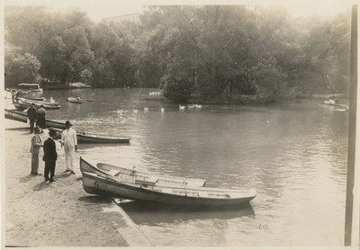 Personas junto a las embarcaciones en el lago chico