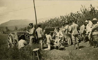 Militares maniobran cañones junto a una milpa, tarjeta postal
