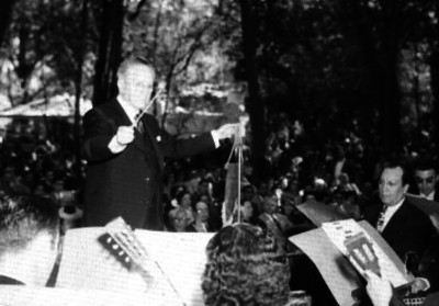 Juan Torreblanca, dirigiendo una orquesta durante un concierto en un parque