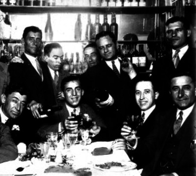 Enrique Torres, torero, conviviendo con varios hombres en un bar, retrato de grupo