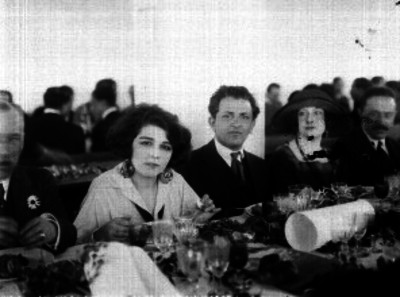 Heliodoro Valle acompañdo de una dama de la Cia. Camila Quiroga y otras personas durante un banquete, retrato de grupo