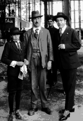 José Luis Velasco caminando con un niño y un hombre en una calle, retrato