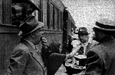 Hombres comprando antojitos a una mujer en una estación