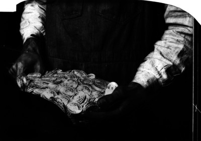 Hombre sostiene recipiente con monedas de un peso Ley.0720