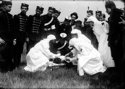 Enfermeras y militares atendiendo a herido militar durante prácticas en un campo