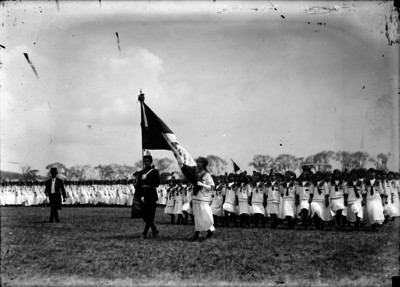 Alumnas de la Escuela Normal escoltando la Bandera de los preparatorianos durante ceremonia en el Hipódromo