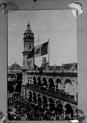 Personas observan el izamiento de la bandera en el Palacio Municipal del Puerto de Veracruz