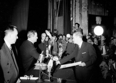 Manuel Ávila Camacho entrega reconocimiento a un hombre en público, ceremonia del 2° aniversario de alfabetización
