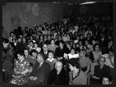 Mujeres, hombres y niños en un acto público