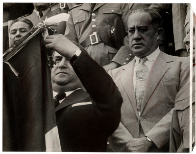 Manuel Ávila Camacho acompañado por su hermano y militares, condecorando la bandera Nacional