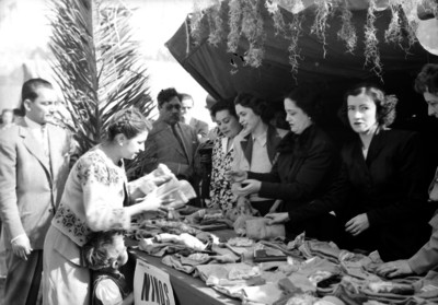 Beatriz Velasco de Alemán y mujeres entregando donativos a niños