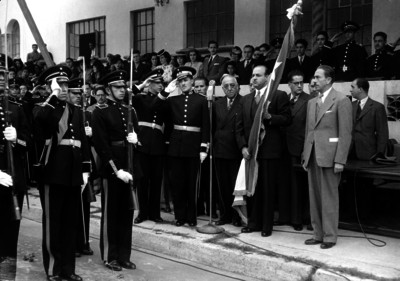 Gustavo Baz y funcionarios realizando honores en una ceremonia