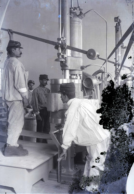 Hombres maniobran las máquinas de fabricación de armamento