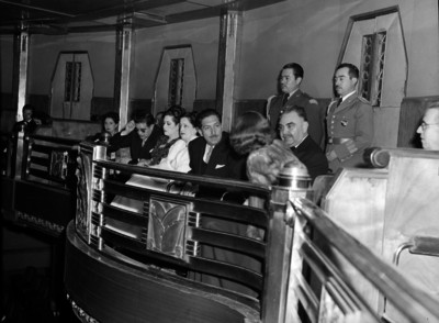 Miguel Alemán conversando con una mujer en un palco