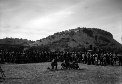 Espectadores observan maniobras de elementos de infantería en un campo militar
