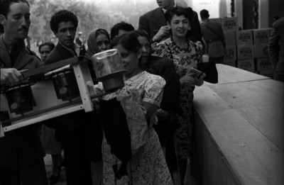 Funcionarios entregando a una mujer utensilios domésticos