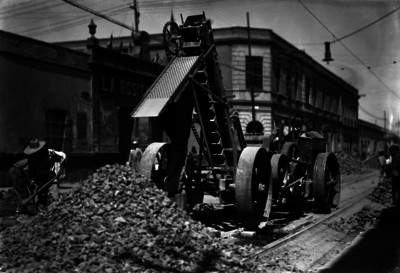 Trabajadores con procesadora de piedra durante la pavimentación de una calle