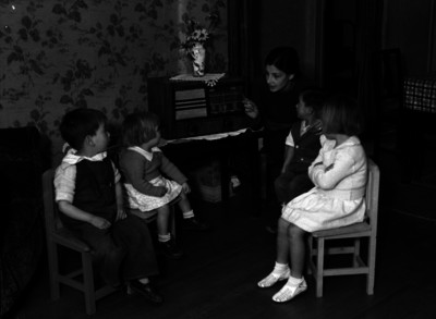 Mujer y niños escuchan radio en una casa hogar
