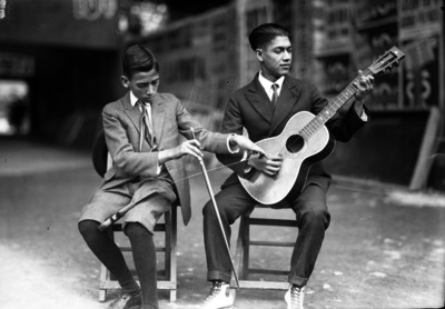 Musico tocando la guitarra sentado en una silla