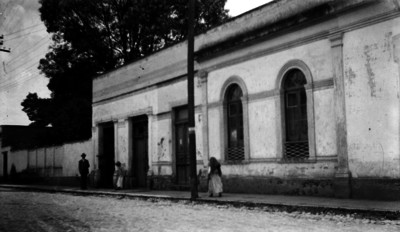 Gente camina junto a una calle empedrada