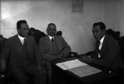 Jesús Zavala conversando en una oficina con dos hombres vestidos de traje