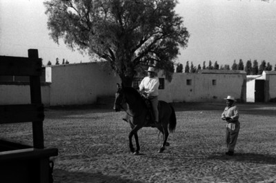 Hombre a caballo y campesino caminando por la calle de un poblado de la ciudad de Guanajuato