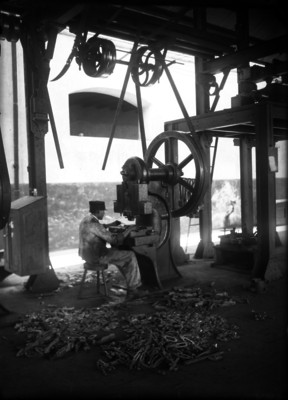 Trabajador operando una máquina para fabricar armas