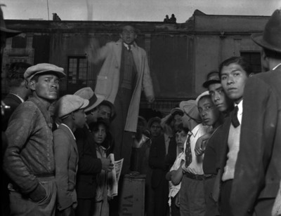 Hombre hablando ante trabajadores en un calle